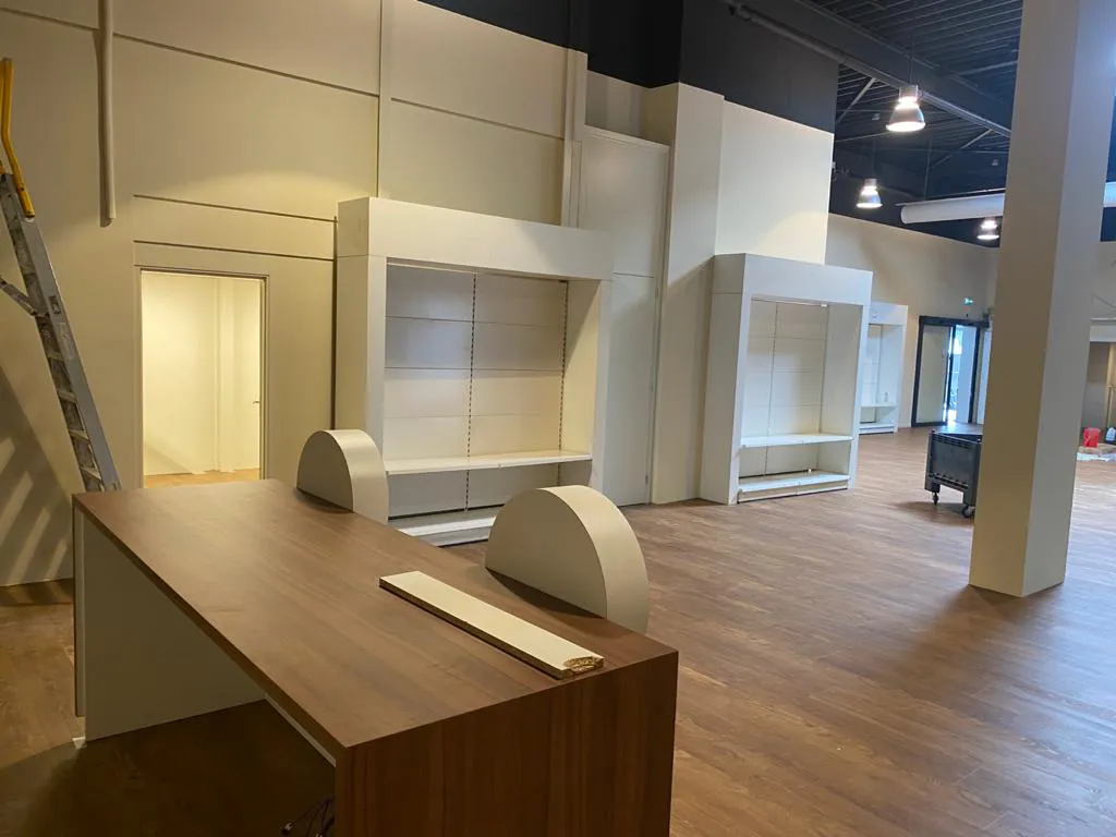 Winkelruimte met maatwerk balie en wandkasten tijdens de afbouw
