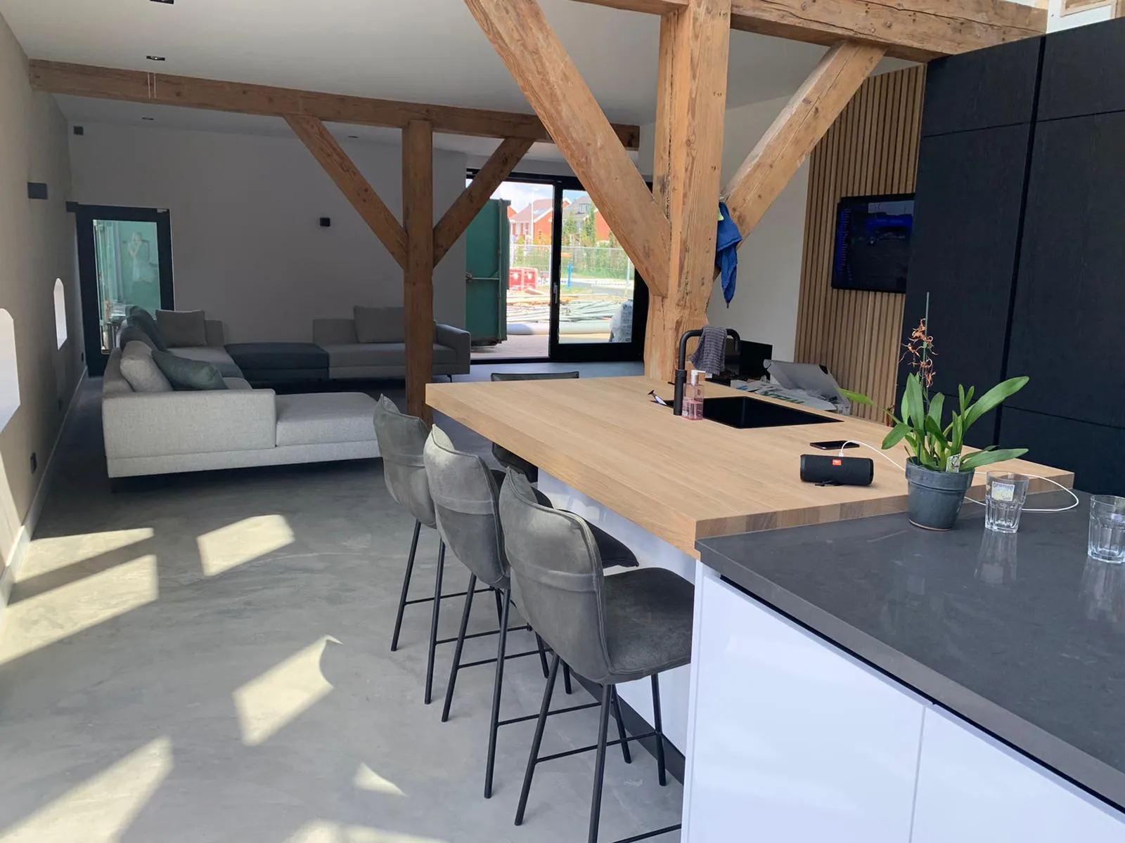 Afgewerkte keuken onder de oorspronkelijke houten spanten van een boerderij