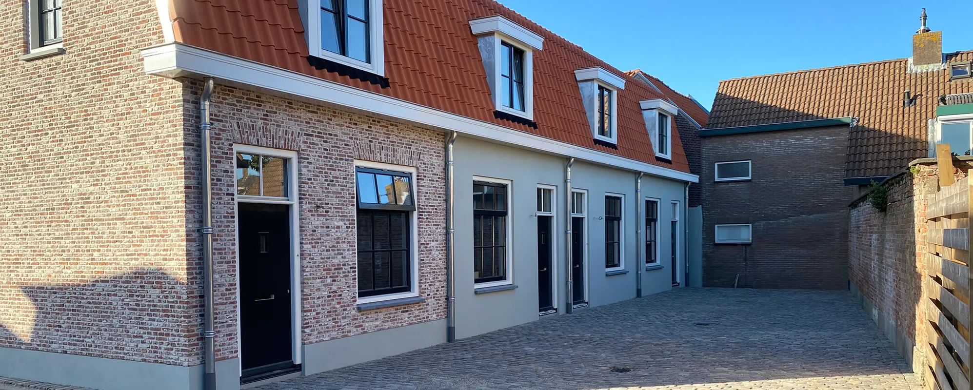 Rij woningen aan de Molenwal met gemetselde gevels en een binnenplaats