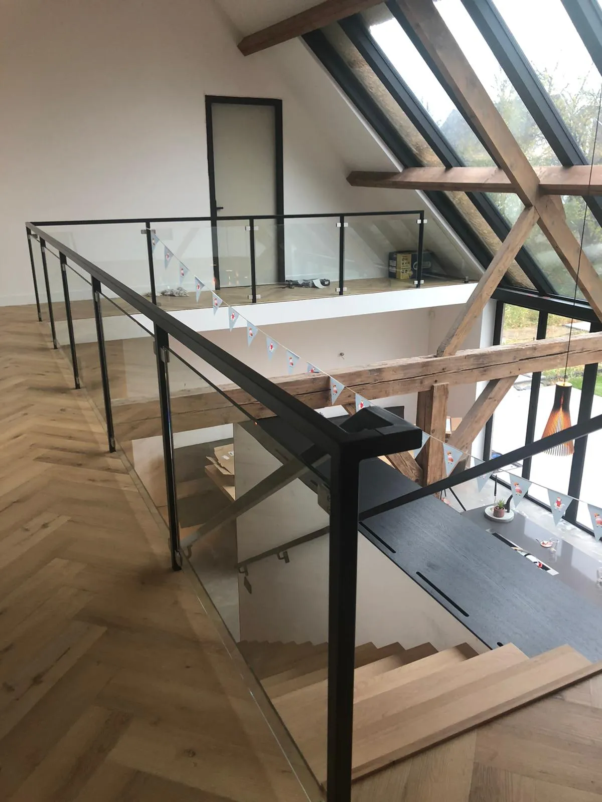 Trap en vide met houten spanten en glazen balustrade