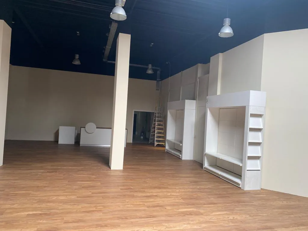 Lege winkelruimte met donker plafond en witte wandmeubels