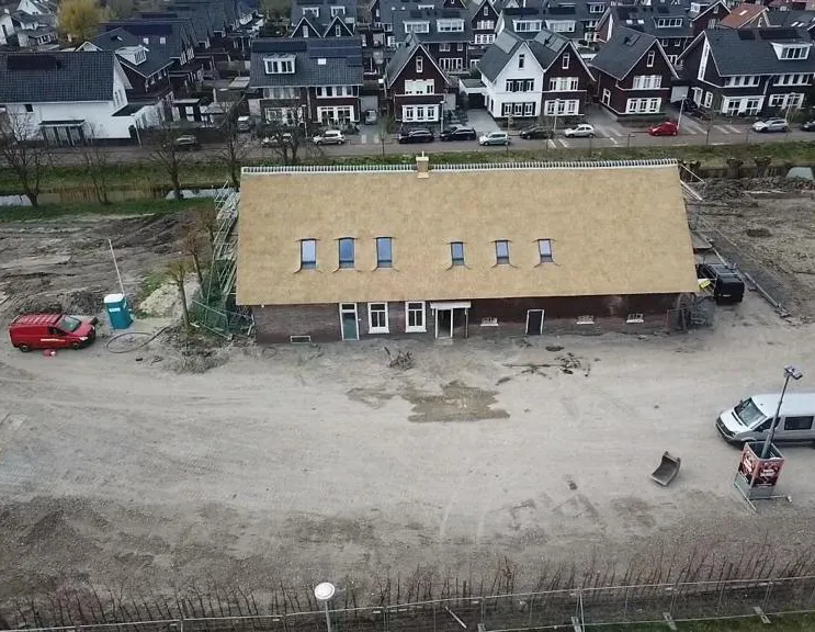 Luchtfoto van de gerestaureerde boerderij met nieuw rieten dak