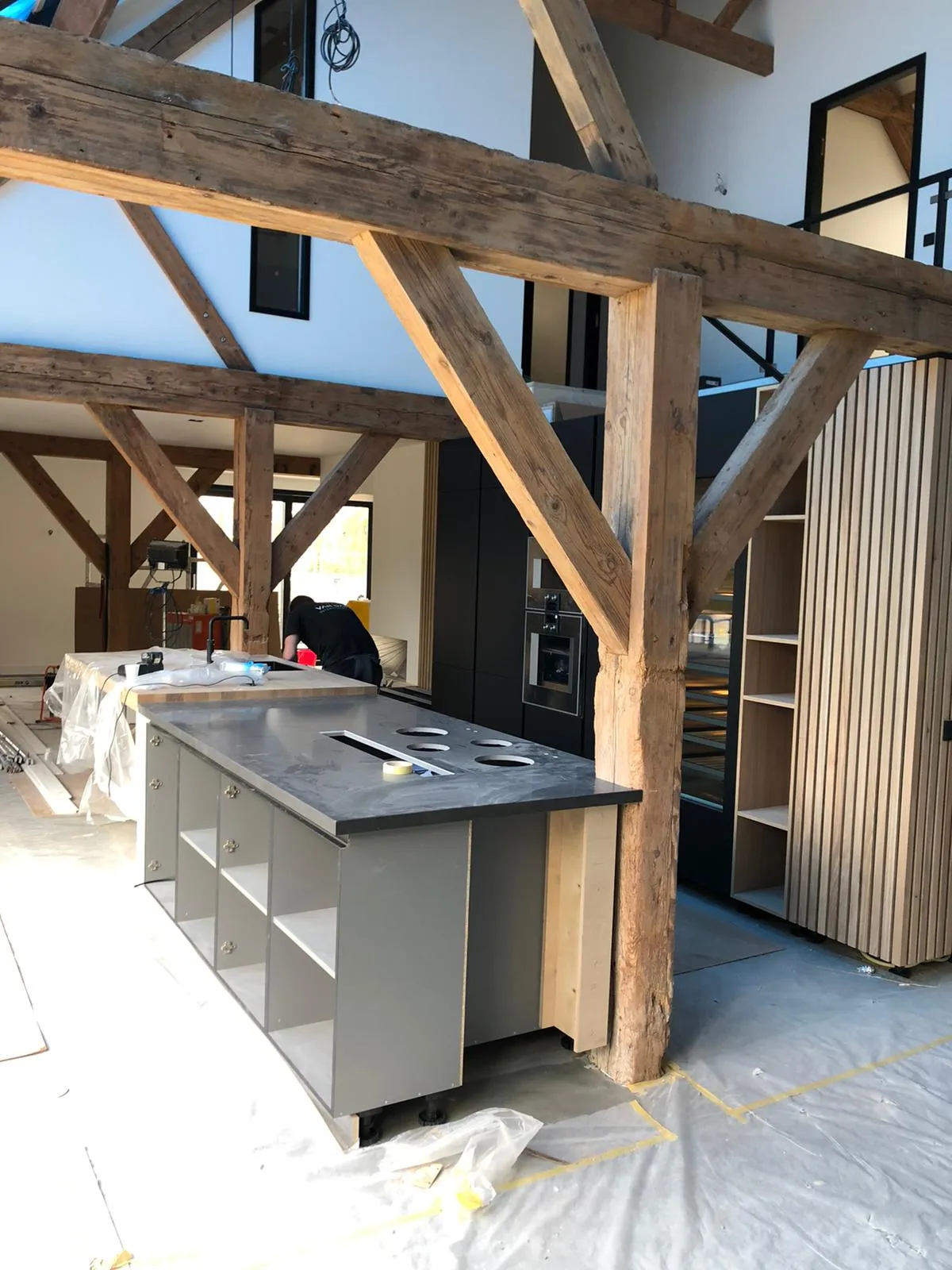 Keukeneiland in afbouw tussen de houten gebinten